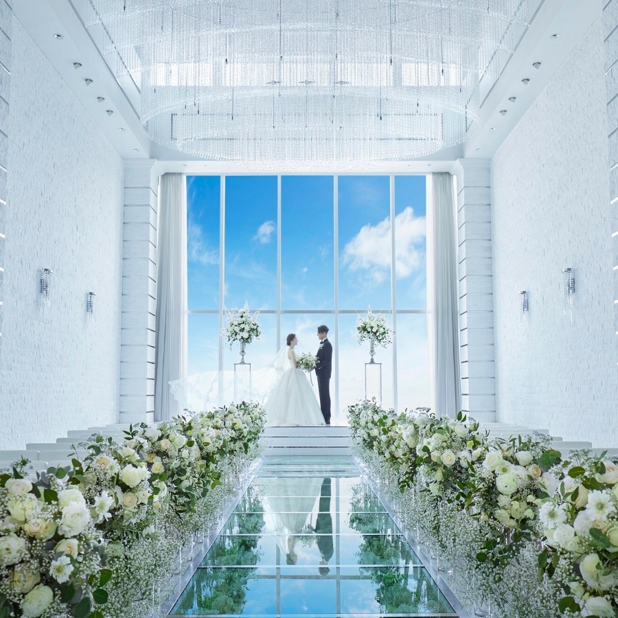 陽光差し込む大きな窓と花々を敷き詰めた15mのバージンロードが特徴の大空間
