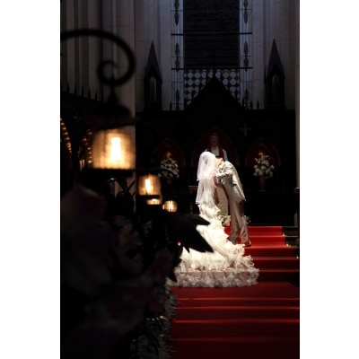 スポットライトの下で誓いのキス。バージンロードの赤と純白のウエディングドレスが、雰囲気をより一層引き立てていますね♪