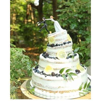 ウェディングケーキは、ケーキトッパーの動きを活かして4段のケーキの1段目と2段目を傾けて、崩れそうなデザインにしていただいたのだとか。ケーキのデコレーションは、フルーツと葉っぱでナチュラルに＊
