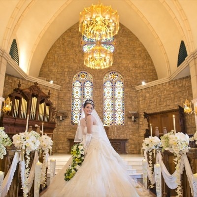 ロングトレーンのウエディングドレスがよく映え、花嫁を美しく彩る