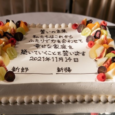 パーティーの中盤には、おふたりの誓いの言葉が記されたウェディングケーキが登場。

秋のフルーツで美しく彩られたウェディングケーキ。

おふたりにチョコペンでサインをいただき完成しました。