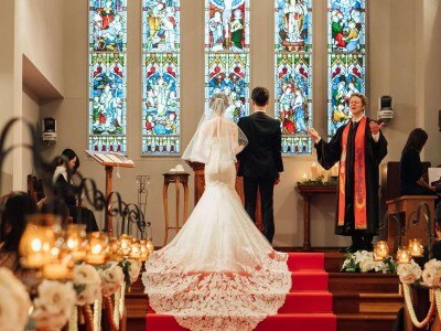 祭壇前階段の赤じゅうたんの上に長いトレーンが美しく映え、花嫁の美しさを一層高める