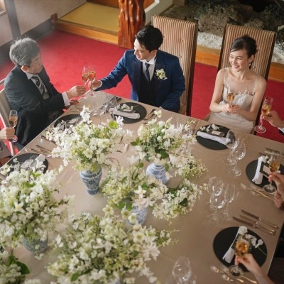 赤い絨毯に映える祝宴は、少人数ながら華やか。大きなテーブルを囲んで和やかに乾杯を<br>【披露宴】披露宴会場　松緑／2～30名