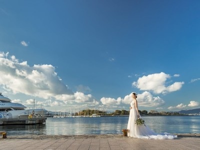 青い空と青い海と停泊する船……港町ならではのロケーションに花嫁姿も美しく映える