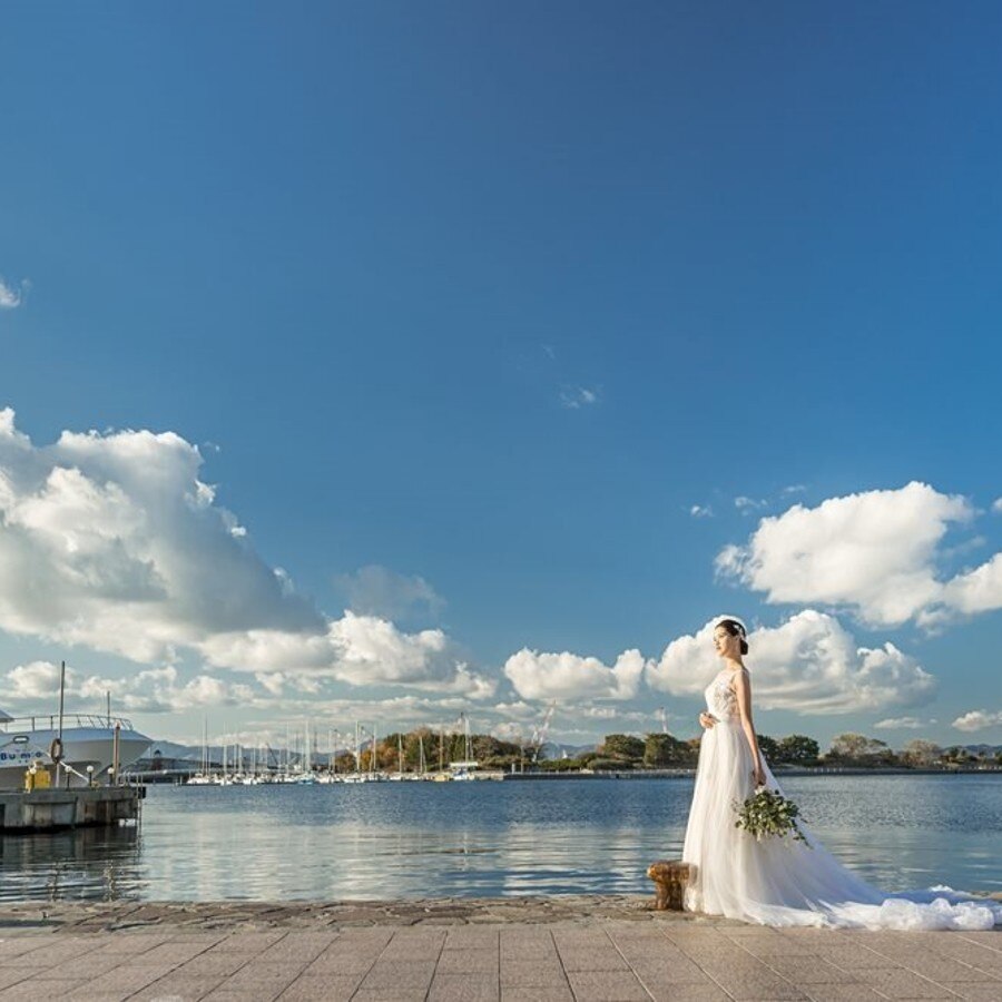 青い空と青い海と停泊する船……港町ならではのロケーションに花嫁姿も美しく映える