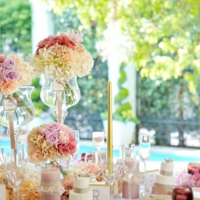 ピンクの差し色が可愛い装花と甘いテイストの小物を併せればプリンセス気分を味わえる<br>【披露宴】会場装飾例