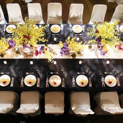 黒いテーブルと黄色い花のコントラストが美しい、シックで華やかなコーディネート<br>【披露宴】披露宴