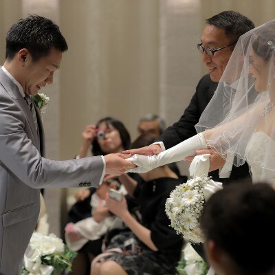 お父様から新郎様へ新婦様の手を渡される感動の瞬間です。新郎様は緊張されながらも新婦様の手をしっかりと受け取られました。そして、おふたりは腕を組まれ、皆様に見守られながら永遠の愛を誓われました。