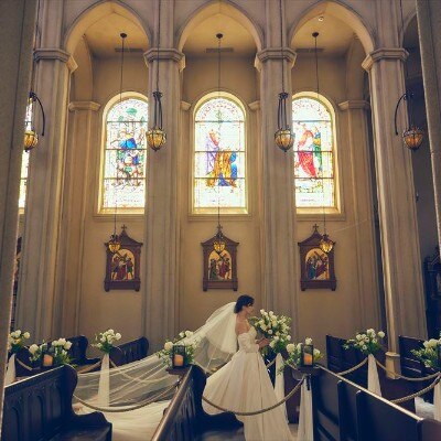 ステンドグラスから差し込む光に浮かび上がるクラシカルな堂内と花嫁が印象的<br>【挙式】チャペル　セント・ヴァレンタイン大聖堂／30～100名（着席）