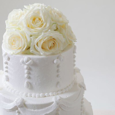 ウェディングケーキのトップには花嫁をイメージした白い薔薇<br>【料理・ケーキ】ケーキ