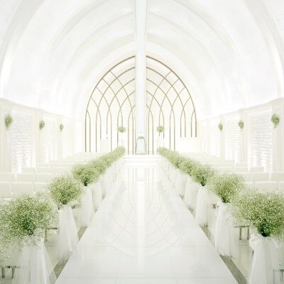 天井からバージンロードまで純白で統一されたチャペルに花嫁の白いドレスが映える