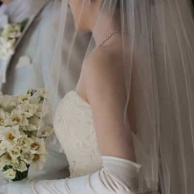 胸元の刺繍と白いバラで統一された上品なブーケが花嫁さまの美しさをより際立たせる…