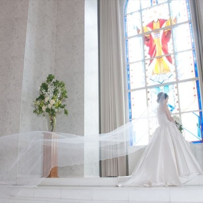 ステンドグラスから差す自然光が、純白のドレスを纏った花嫁を包み込む神秘的な空間<br>【挙式】北九州最大級のチャペル「聖マリエ・ド・クー」／～140名