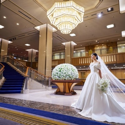 重厚感あるロビーでゲストをもてなす、ロビー装花と豪華なシャンデリア<br>【ドレス・和装・その他】130年の歴史を紡ぐ。歴史と革新が共存する「帝国ホテル 東京」の結婚式