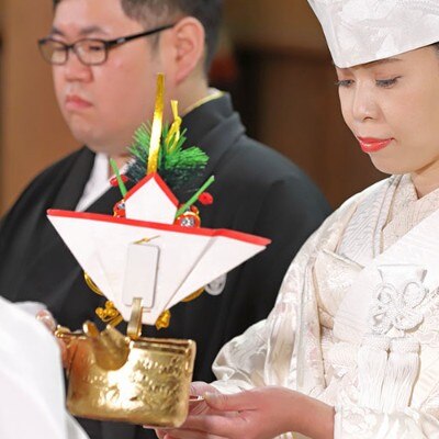 ふたりが同じ杯から交互にお神酒をのむ三々九度は、神前式を象徴する感動の場面<br>【挙式】挙式