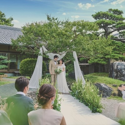青空の下での庭園挙式は開放感満点。フラワーシャワーなど多彩な演出がかなうのも魅力<br>【挙式】日本庭園でのセレモニー