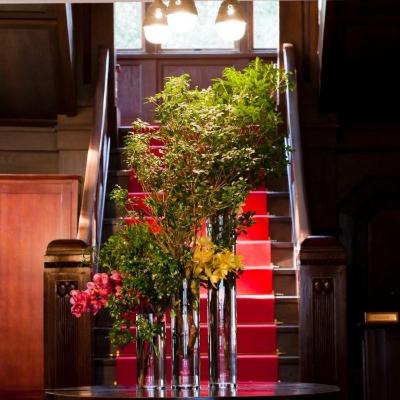 二階のメイン会場へと続く階段下を希望の装花で飾ることも。深紅のカーペットが印象的