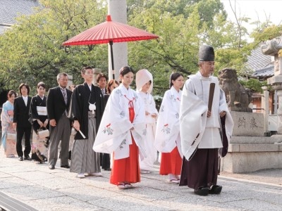 朱傘を差して親族と共に参道を歩む「参進の儀」で、桑名総鎮守の神様のもとへ進んで